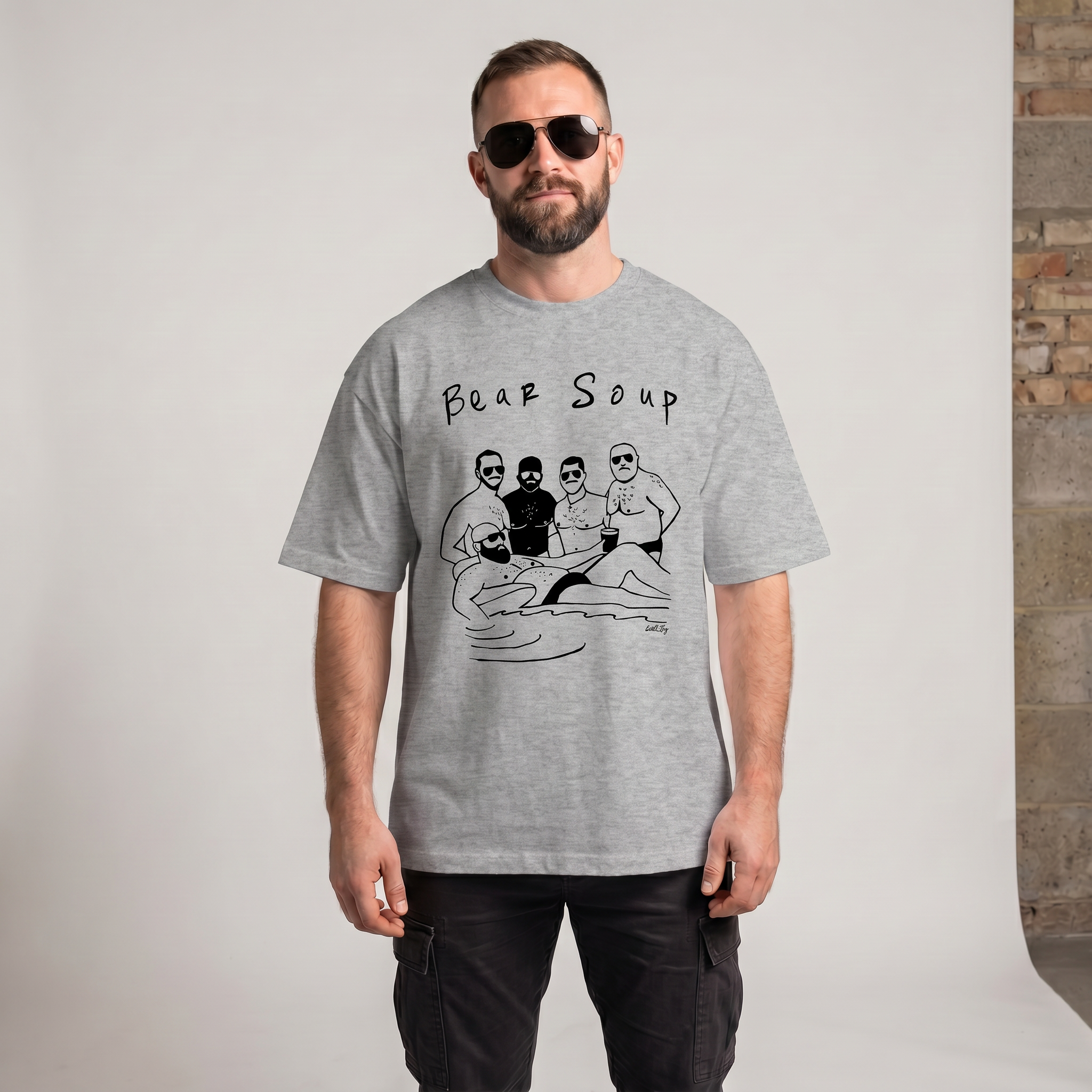 A man wearing sunglasses and a "Bear Soup" t-shirt is being photographed in a studio.